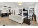 Spacious living room with fireplace, hardwood floors, modern furniture, and seamless flow to kitchen at 12874 Tradd St, Carmel, IN 46032