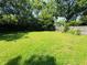 View of spacious backyard with lush green grass and wooden fence at 1345 S Biltmore Ave, Indianapolis, IN 46241