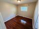 A vacant bedroom featuring hardwood floors, tan walls, and a single window at 1345 S Biltmore Ave, Indianapolis, IN 46241