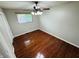 Bright bedroom with hardwood flooring, ceiling fan, and window at 1345 S Biltmore Ave, Indianapolis, IN 46241