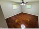 A vacant bedroom featuring hardwood floors, two windows, and tan walls at 1345 S Biltmore Ave, Indianapolis, IN 46241