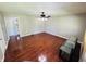 An empty living room featuring hardwood floors, a ceiling fan, and access to other parts of the house at 1345 S Biltmore Ave, Indianapolis, IN 46241