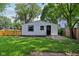 Backyard featuring well-maintained grassy lawn, privacy fences, and a small building with black door at 1648 Ringgold Ave, Indianapolis, IN 46203