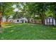 Spacious backyard featuring a well-maintained lawn, wooden fencing, a small shed, and mature trees for added shade at 1648 Ringgold Ave, Indianapolis, IN 46203