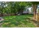Large grassy backyard enclosed by a wood fence with mature trees enhancing privacy and shade at 1648 Ringgold Ave, Indianapolis, IN 46203