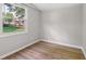Light-filled bedroom featuring light grey walls, wood flooring, and a window view at 1648 Ringgold Ave, Indianapolis, IN 46203