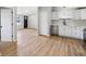 Open-concept kitchen with stainless steel appliances and white cabinetry, complemented by light wood flooring at 1648 Ringgold Ave, Indianapolis, IN 46203