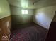 View of a small bedroom showing old carpet, outdated walls, and basic lighting fixture at 1816 E Highland Ave, Muncie, IN 47303