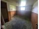 Bedroom with worn carpet, wood paneled walls, and standard window at 1816 E Highland Ave, Muncie, IN 47303
