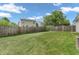 Large backyard with wooden fence, lush green lawn and shade trees perfect for outdoor activities at 1912 Blue Pine Ln, Indianapolis, IN 46231