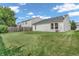 Spacious backyard with a full lawn, wood fence, and white vinyl siding on home at 1912 Blue Pine Ln, Indianapolis, IN 46231