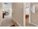 Inviting hallway featuring neutral walls and carpeting, with views into the living spaces and bedrooms at 1912 Blue Pine Ln, Indianapolis, IN 46231