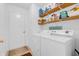Well-lit laundry room equipped with a washer, dryer, and ample shelving at 1912 Blue Pine Ln, Indianapolis, IN 46231