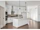 Bright, modern kitchen boasts white cabinetry, stainless steel appliances, a large island, and wood flooring at 19995 Gansett Rd, Westfield, IN 46074