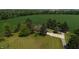 Aerial view of property showing home with mature landscaping and large cultivated field to the north at 2000 Hawthorne Dr, Plainfield, IN 46168