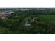 Aerial showing the house, outbuildings, and farm with stores in the distance at 2000 Hawthorne Dr, Plainfield, IN 46168