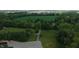 Scenic aerial view of a lush property featuring mature trees and a green field at 2000 Hawthorne Dr, Plainfield, IN 46168