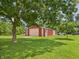 Large barn with red and tan exterior, offering ample storage and workspace, adjacent to a well-manicured lawn at 2000 Hawthorne Dr, Plainfield, IN 46168