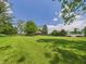 View of lush green lawn, mature trees, house, and barn on a sunny day at 2000 Hawthorne Dr, Plainfield, IN 46168