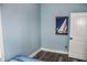 Clean bedroom with nautical wall art, light blue paint, and white trim around the door at 206 Olive St, Arcadia, IN 46030