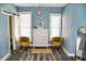 Stylish bedroom with blue walls, two yellow chairs, white dresser, and modern decor for a comfortable retreat at 206 Olive St, Arcadia, IN 46030