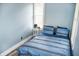 Cozy bedroom with a blue striped bedspread, bedside table, and natural light from the window at 206 Olive St, Arcadia, IN 46030
