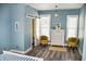 Bright bedroom featuring a sliding barn door, light blue walls, and stylish yellow accent chairs at 206 Olive St, Arcadia, IN 46030