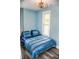 Inviting bedroom featuring a comfortable blue bedspread, a modern ceiling fan, and a bright window at 206 Olive St, Arcadia, IN 46030