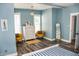 Bedroom features blue accent wall, wood floors, a chest of drawers and accent chairs at 206 Olive St, Arcadia, IN 46030