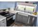 Well-lit kitchen with an apron sink, stainless steel appliances, and gray cabinetry at 206 Olive St, Arcadia, IN 46030