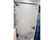 White tiled shower with glass shelving and contrasting mosaic tile flooring at 206 Olive St, Arcadia, IN 46030
