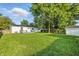 Expansive backyard featuring a deck, lush green lawn, and mature trees, ideal for outdoor activities at 212 N 13Th St, Elwood, IN 46036