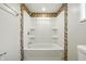 Bathroom with mosaic tile surround, and a bright, white, bathtub and shower at 212 N 13Th St, Elwood, IN 46036
