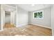 This bedroom features wood-look flooring, neutral walls, and a window with bright natural light at 212 N 13Th St, Elwood, IN 46036