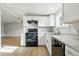Modern kitchen featuring white cabinets, a black range and views into the large living area at 212 N 13Th St, Elwood, IN 46036