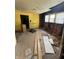 Kitchen in disrepair, with yellow walls, missing cabinets, and exposed infrastructure at 2215 Noble St, Anderson, IN 46016