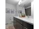 Bathroom featuring double sink vanity, modern fixtures, framed artwork, and a shower-tub combo with gray tiled wall at 2326 Prospect St, Indianapolis, IN 46203