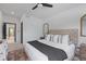 Serene bedroom with a tufted headboard, soft bedding, and a decorative mirror, plus tranquil natural light at 2326 Prospect St, Indianapolis, IN 46203