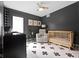 Neutral Bedroom showcases a cozy chair, a crib, a modern ceiling fan, and a patterned black and white area rug at 2326 Prospect St, Indianapolis, IN 46203
