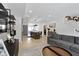 Open-concept living space with a gray sofa, light wood flooring, and a view of the kitchen island at 2326 Prospect St, Indianapolis, IN 46203