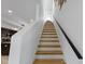 Modern staircase with hardwood treads, a contrasting black handrail, and an open design, plus abundant natural light at 2326 Prospect St, Indianapolis, IN 46203