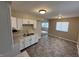 Well-lit kitchen featuring white cabinets and modern countertops and views to an adjacent room with large windows at 2354 Collier St, Indianapolis, IN 46241