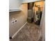 Utility room showing the water heater, furnace, and shelving with tiled flooring at 2354 Collier St, Indianapolis, IN 46241