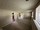 Finished basement with a cozy carpeted area, windows, and a staircase at 2626 Fairhaven Dr, Indianapolis, IN 46229