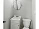 Bathroom features a white vanity, modern fixtures, a toilet, and a round mirror at 2853 S State Ave, Indianapolis, IN 46203