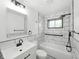 Modern bathroom features a shower-tub combo with black fixtures, white tiling, and a contemporary vanity at 2853 S State Ave, Indianapolis, IN 46203