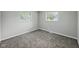 This cozy bedroom features neutral walls, plush carpet, and natural light from two windows at 2853 S State Ave, Indianapolis, IN 46203