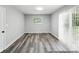 Bright and airy living room with modern gray flooring and natural light from the window and sliding doors at 2853 S State Ave, Indianapolis, IN 46203