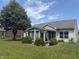 Large backyard featuring a sunroom, lush lawn, mature trees, and manicured bushes at 2929 Tuscarora Ln, Indianapolis, IN 46217
