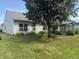 Spacious backyard with mature shade trees, a screened porch, and manicured landscaping at 2929 Tuscarora Ln, Indianapolis, IN 46217